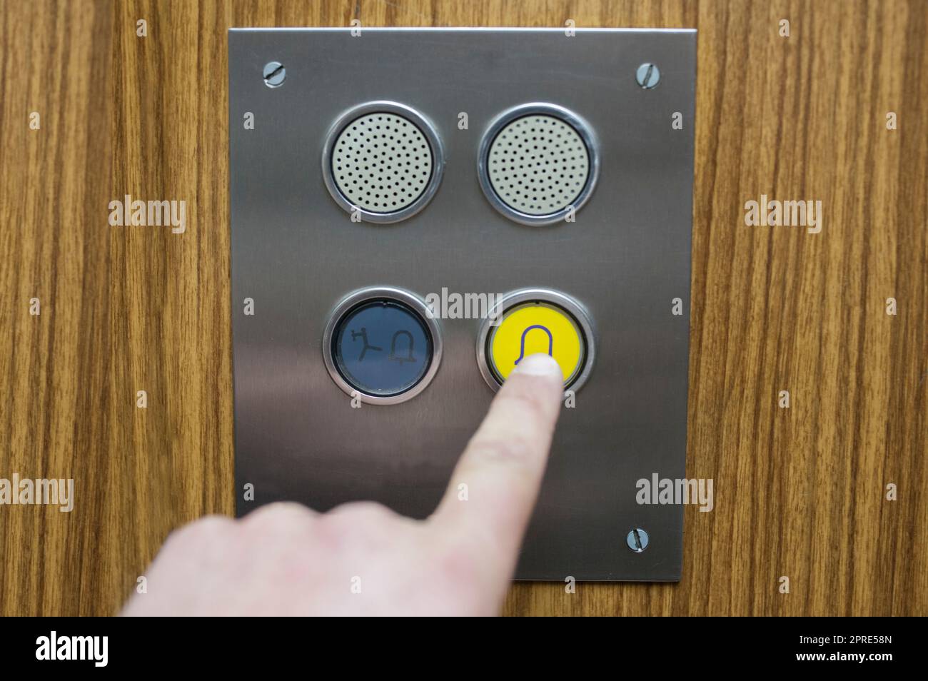 Utilizzo del pulsante per le chiamate di emergenza in un ascensore per le feci. Concetto di manutenzione dell'ascensore obsoleto Foto Stock