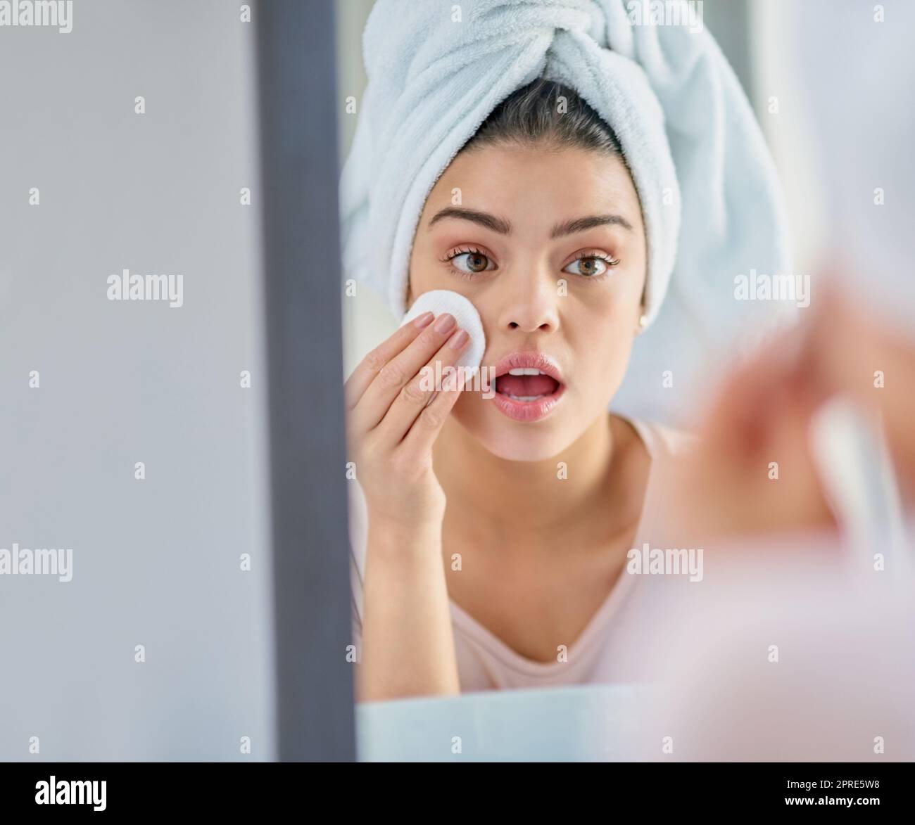Prendendosi cura della sua pelle. Una bella giovane donna esfoliante la sua pelle nel bagno a casa. Foto Stock