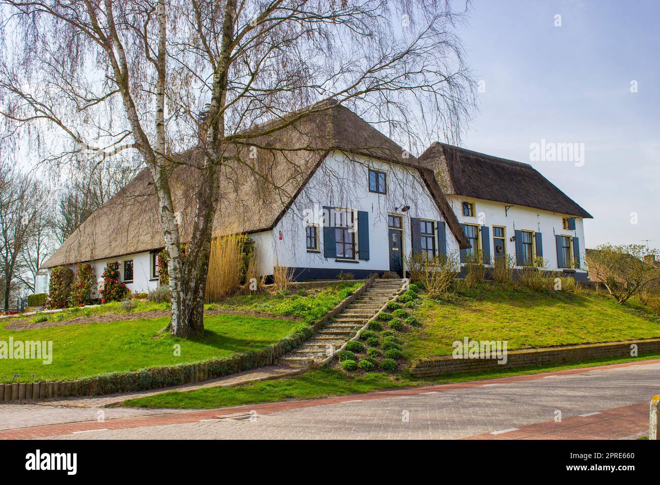 Tipica casa olandese con tetto in paglia, con giardino verde. Casa di campagna, Paesi Bassi Foto Stock