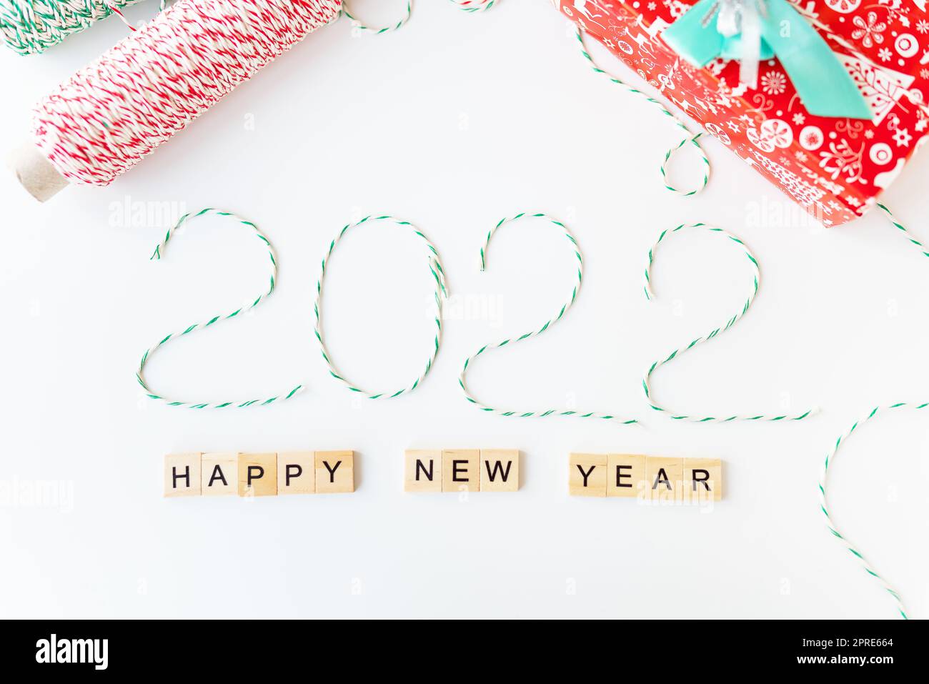 Concetto di vacanza per Natale e Capodanno 2022. Layout di vari attributi natalizi - fili a strisce per la confezione. Vista dall'alto. Foto Stock