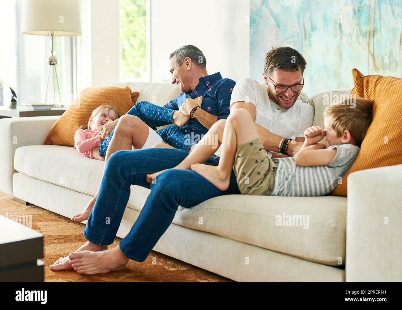 Ottenere la loro dose giornaliera di sollini. Scatto integrale di una famiglia affettuosa di quattro persone sul divano di casa. Foto Stock