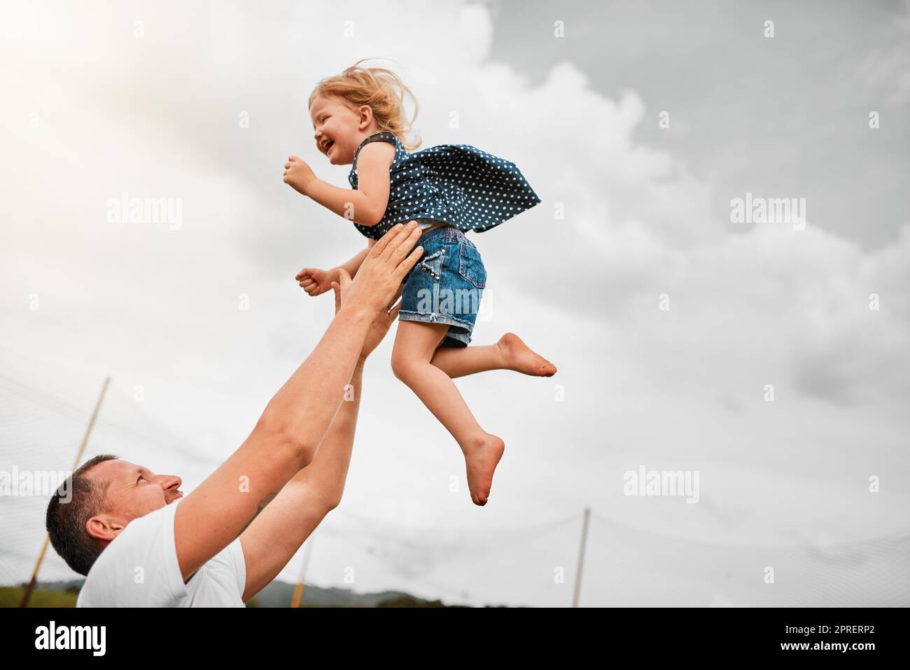 Avendo il miglior tempo mai. Un uomo maturo lancia la sua figlia giovane in aria e poi la cattura fuori. Foto Stock