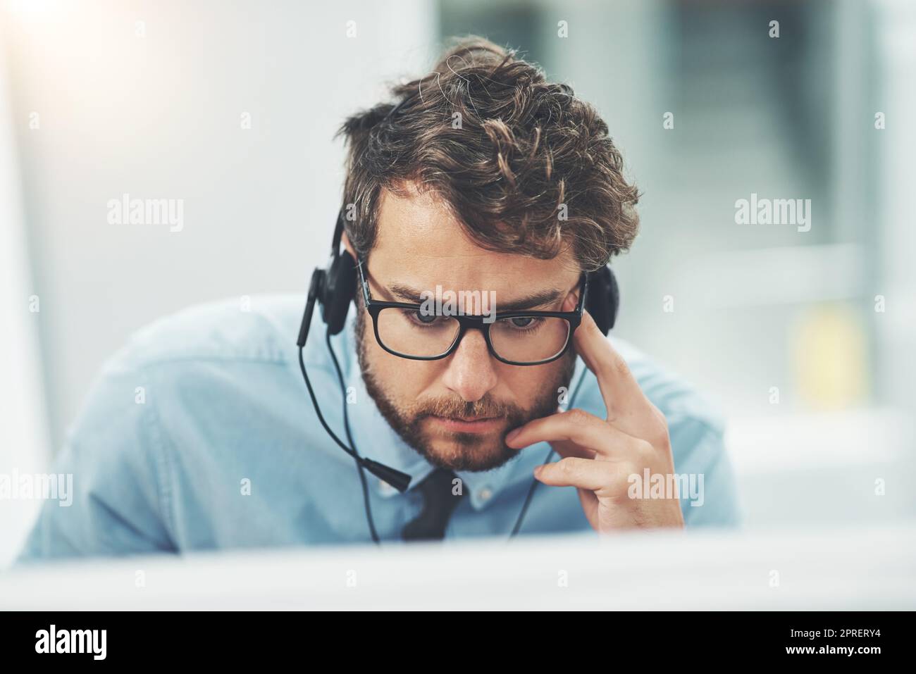 Niente gli impedisce di trovare una soluzione. Un giovane che lavora in un call center. Foto Stock