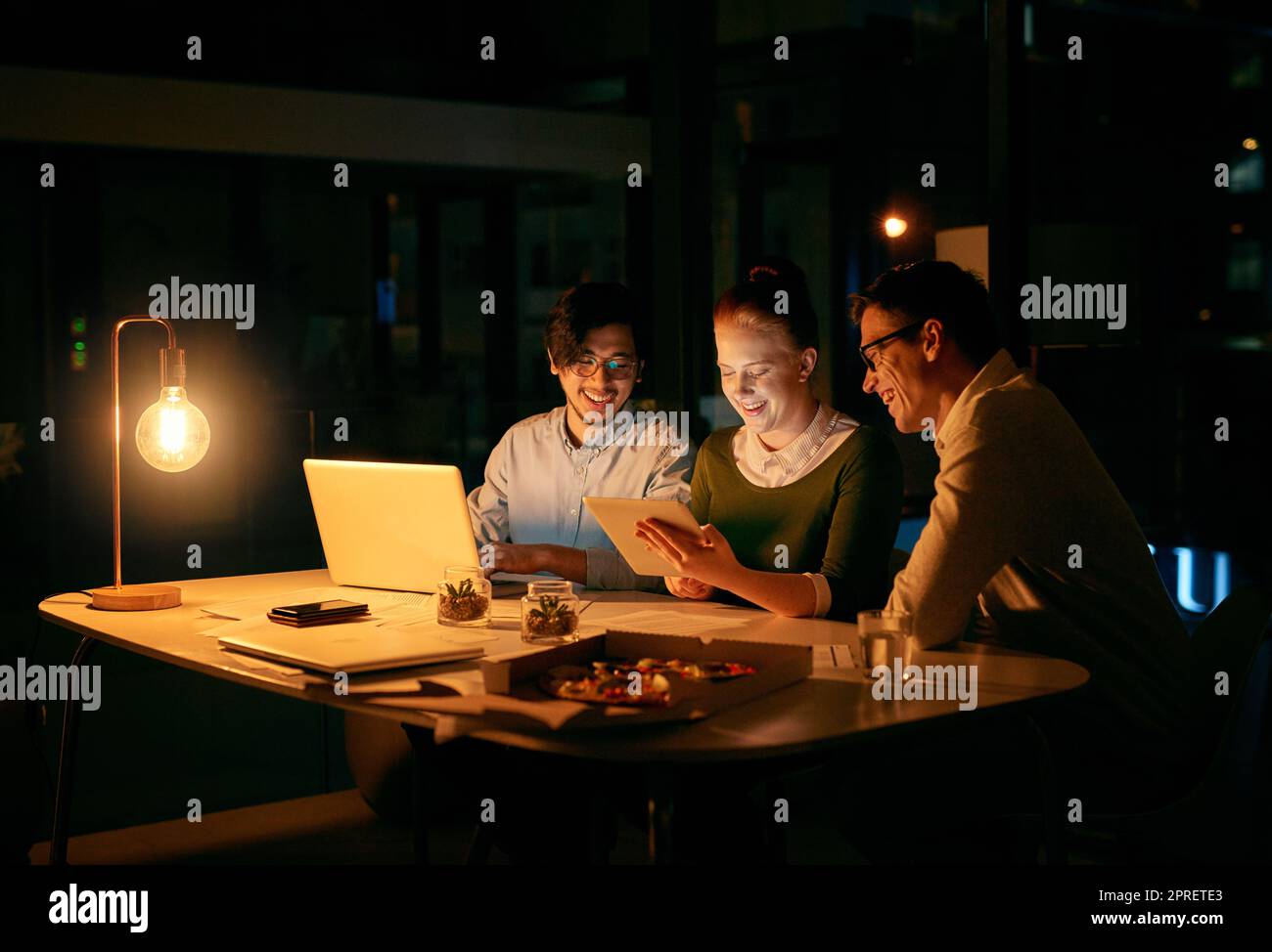 Le lunghe ore di lavoro di squadra non hanno niente a che vedere con il lavoro di squadra. Gli uomini d'affari lavorano insieme su un tablet digitale in ufficio di notte. Foto Stock