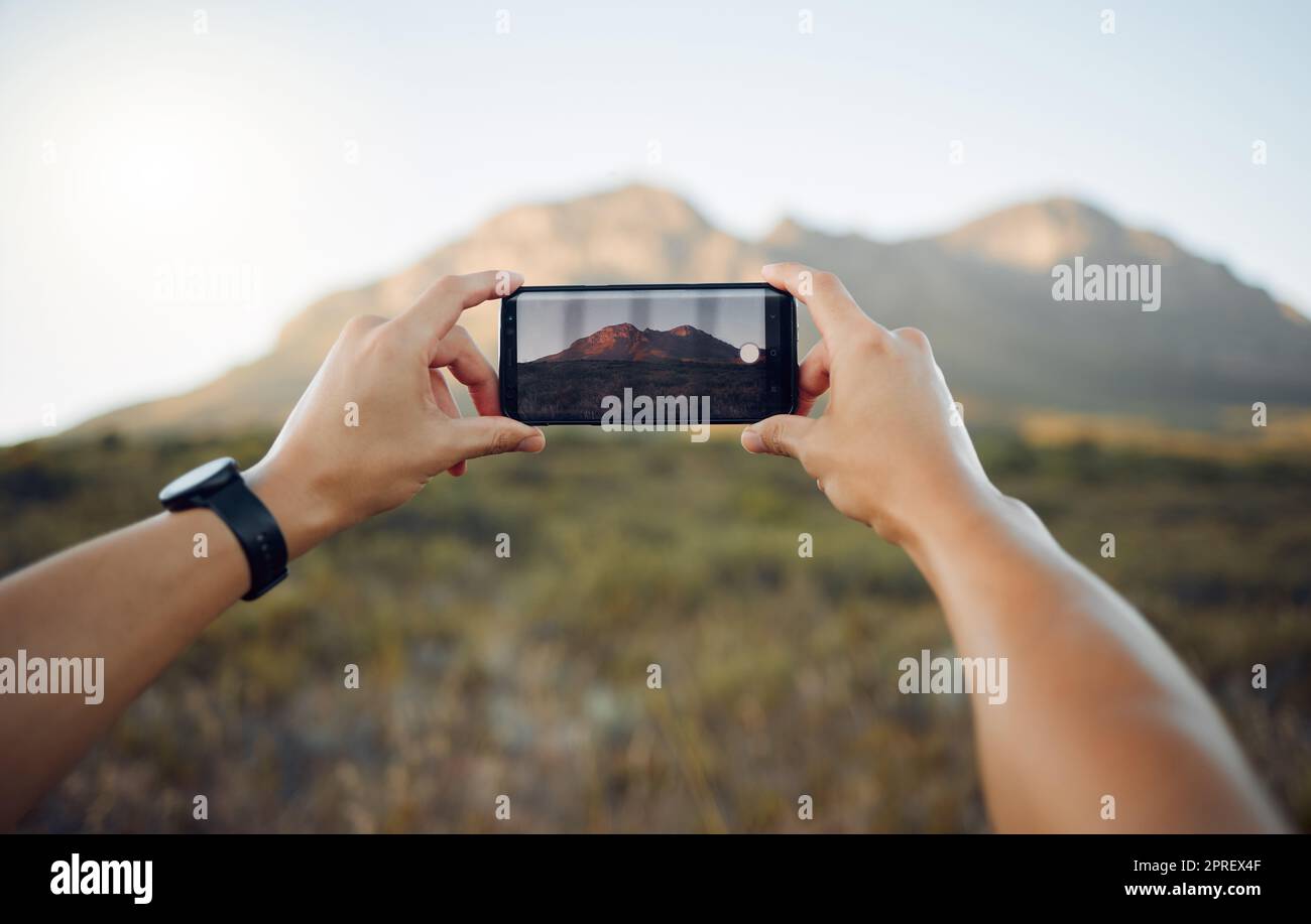 Mani, telefono e foto di montagna in natura per avventure, viaggi e campagna all'aperto. Mano del viaggiatore che scatta una foto degli envi naturali Foto Stock