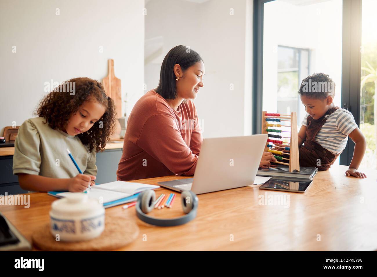 Scuola domestica, sviluppo dei bambini e istruzione di qualità per i bambini piccoli che imparano con la madre. Genitore che aiuta e insegna ai suoi figli con un lavoro scolastico di base o matematica in casa Foto Stock