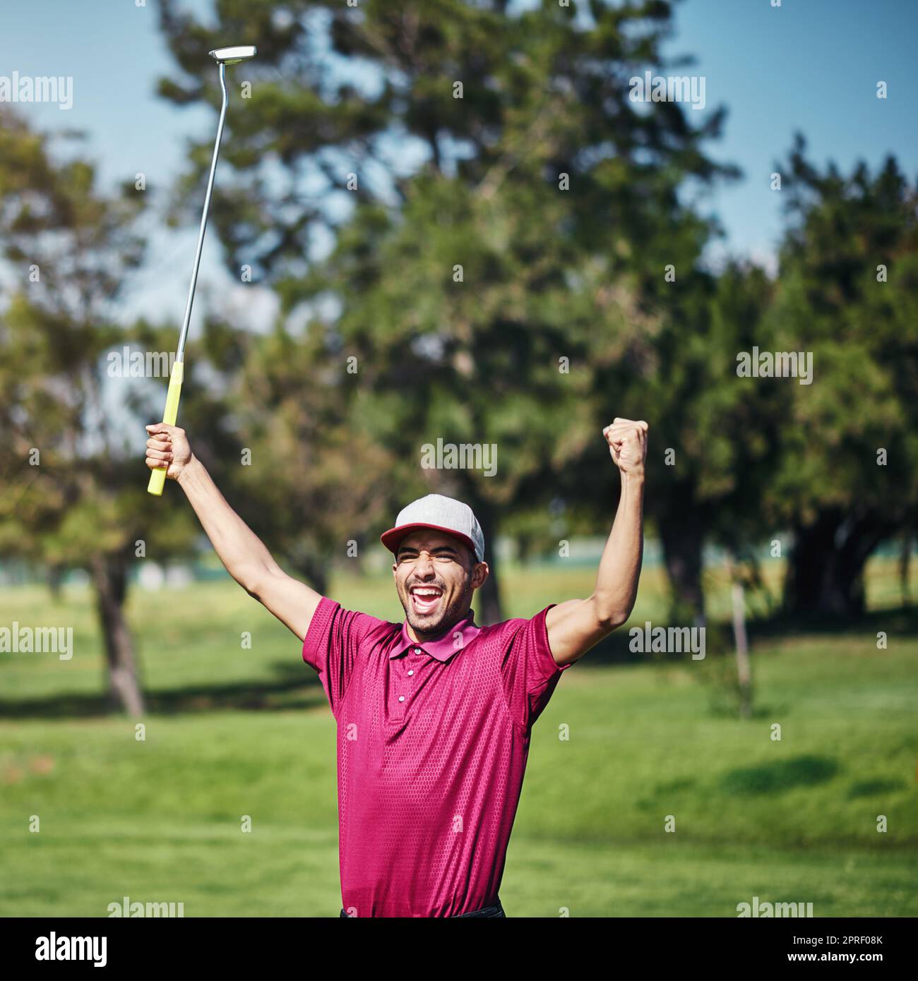 Quello era il colpo migliore tutta la settimana. Un golfer giovane maschio allegro che solleva le sue mani nel successo di giocare un buon colpo fuori durante il giorno. Foto Stock