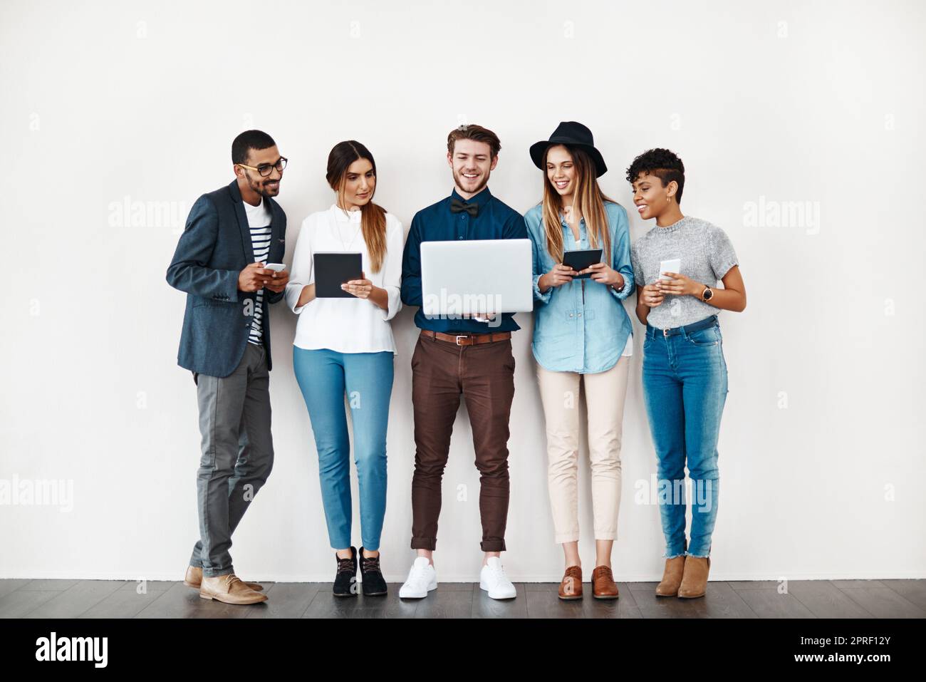 Godere dei vantaggi della connessione. Un gruppo di giovani che utilizza la tecnologia wireless mentre si è in linea. Foto Stock