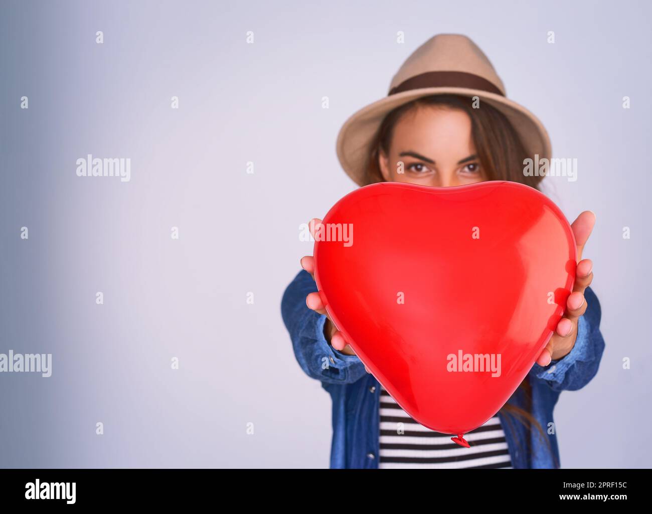 Quello che voglio per San Valentino. Studio shot di una bella giovane donna che posa su uno sfondo viola. Foto Stock