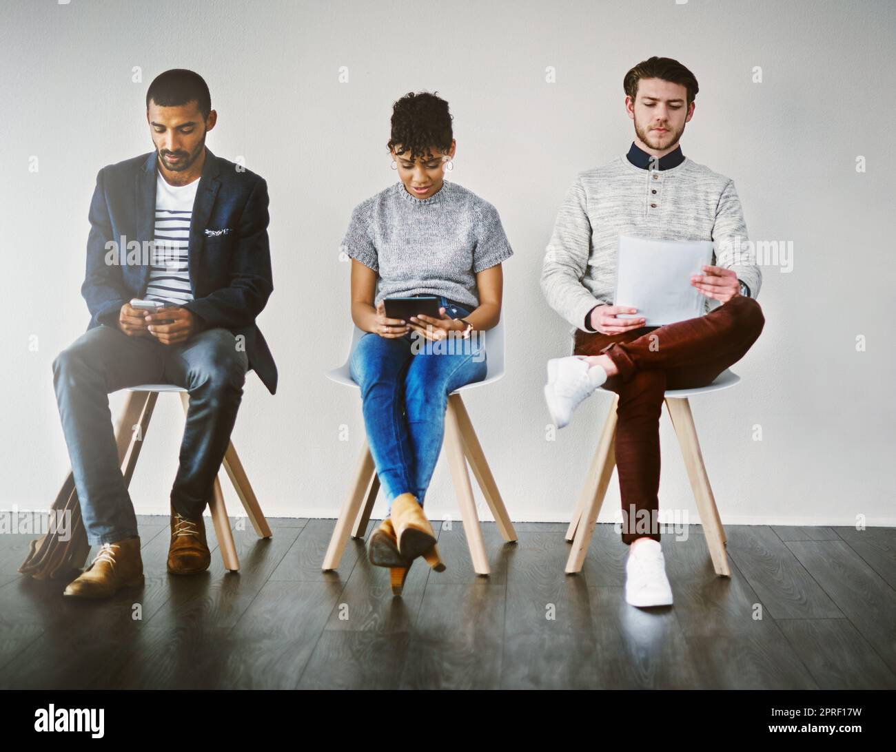 La preparazione è la chiave per una buona intervista: Un gruppo di giovani imprenditori in attesa di un colloquio di lavoro. Foto Stock