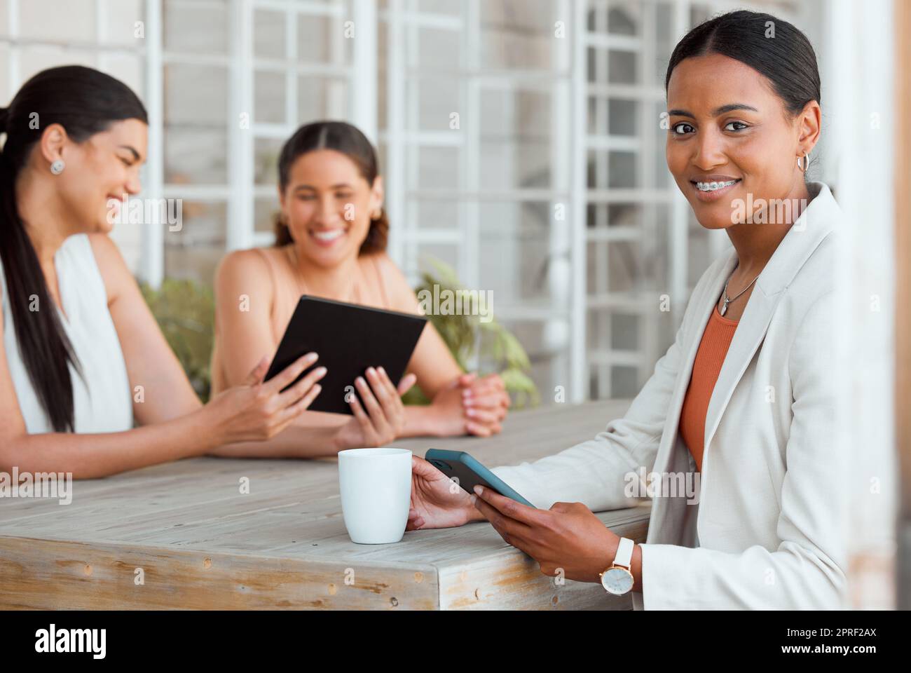 Leadership femminile, innovazione e donna d'affari o colleghi con un tablet, che si godono una pausa caffè o un multitasking durante le riunioni in un luogo di lavoro alla moda. Leader o manager intelligente soddisfatti del ritratto del lavoro Foto Stock