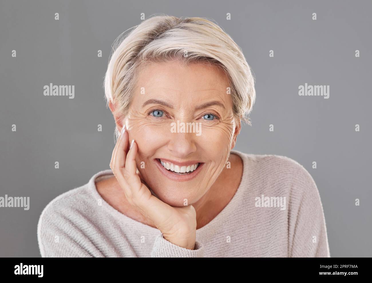 Cura della pelle, bellezza e donna anziana felice o modello viso con denti sani che danno un sorriso su un ritratto in studio alla testa. Chirurgia odontoiatrica, benessere e estetica per le donne anziane per rimanere belle Foto Stock