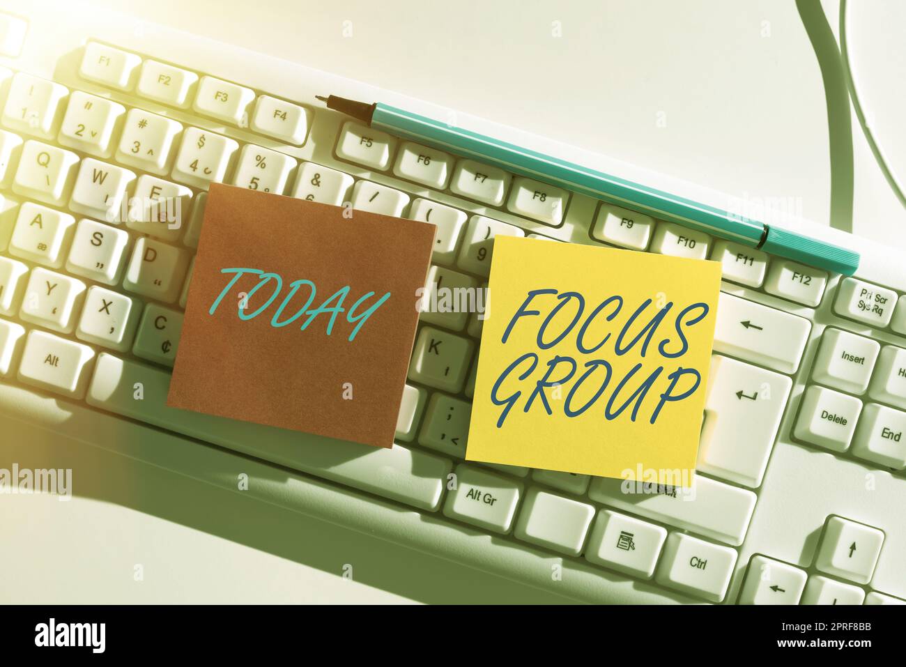 Gruppo Focus didascalia concettuale. Vetrina aziendale che mostra riuniti per partecipare alla discussione su qualcosa di importante messaggi scritti su due Note sulla scrivania con penna e tastiera. Foto Stock
