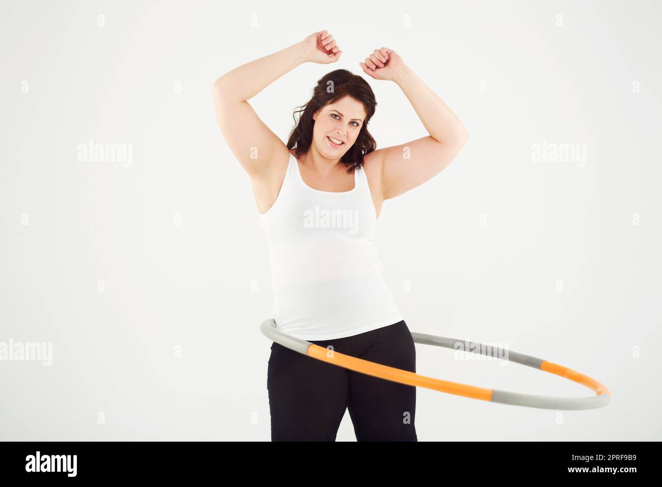 Ottenendo in forma il suo proprio senso. Vista ritagliata di una donna hula ballare mentre isolato su bianco Foto Stock