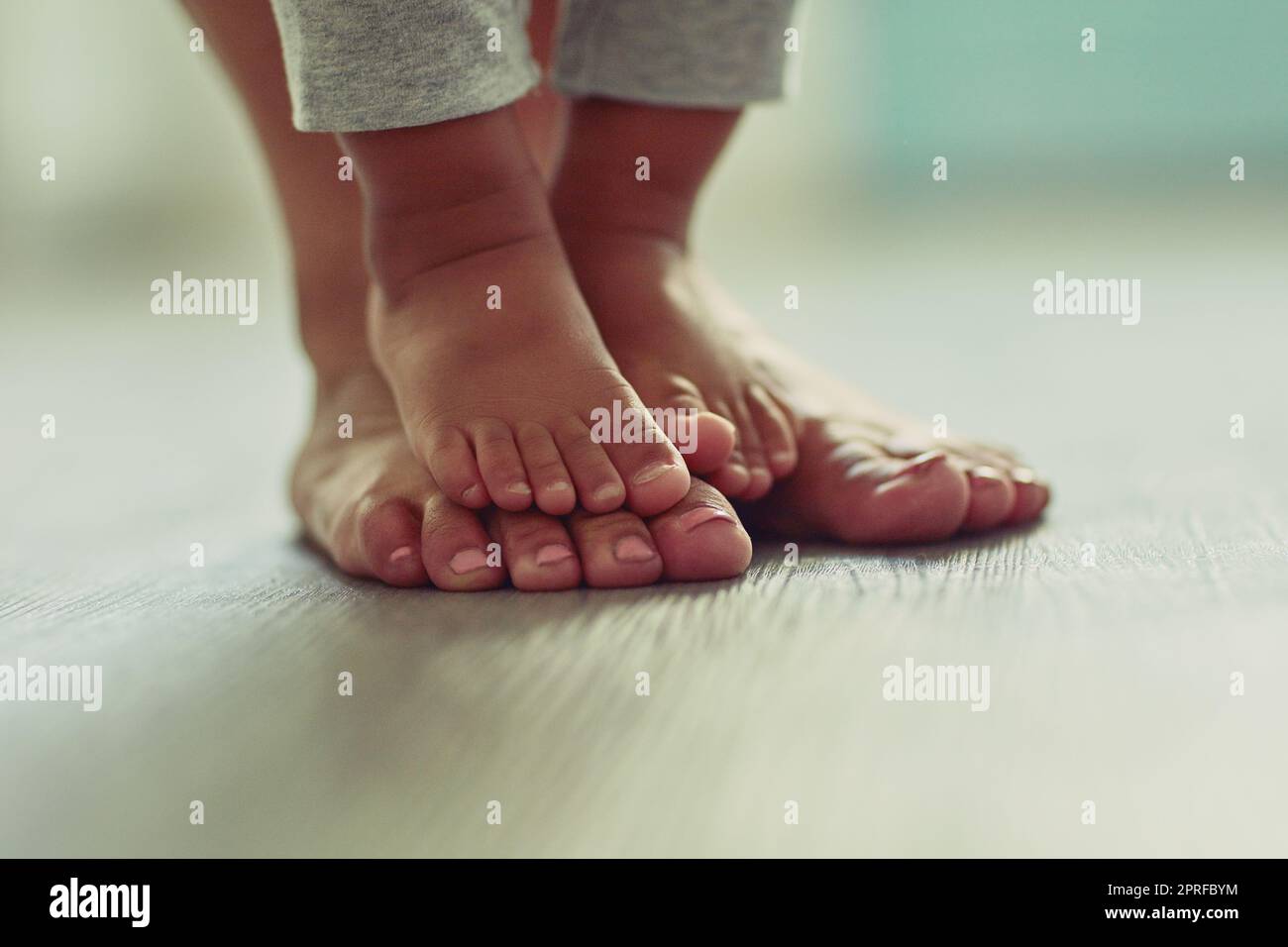 I piedi piccoli rendono la mia vita così dolce. I piedi di una madre irriconoscibile e i piedi dei suoi bambini a casa. Foto Stock