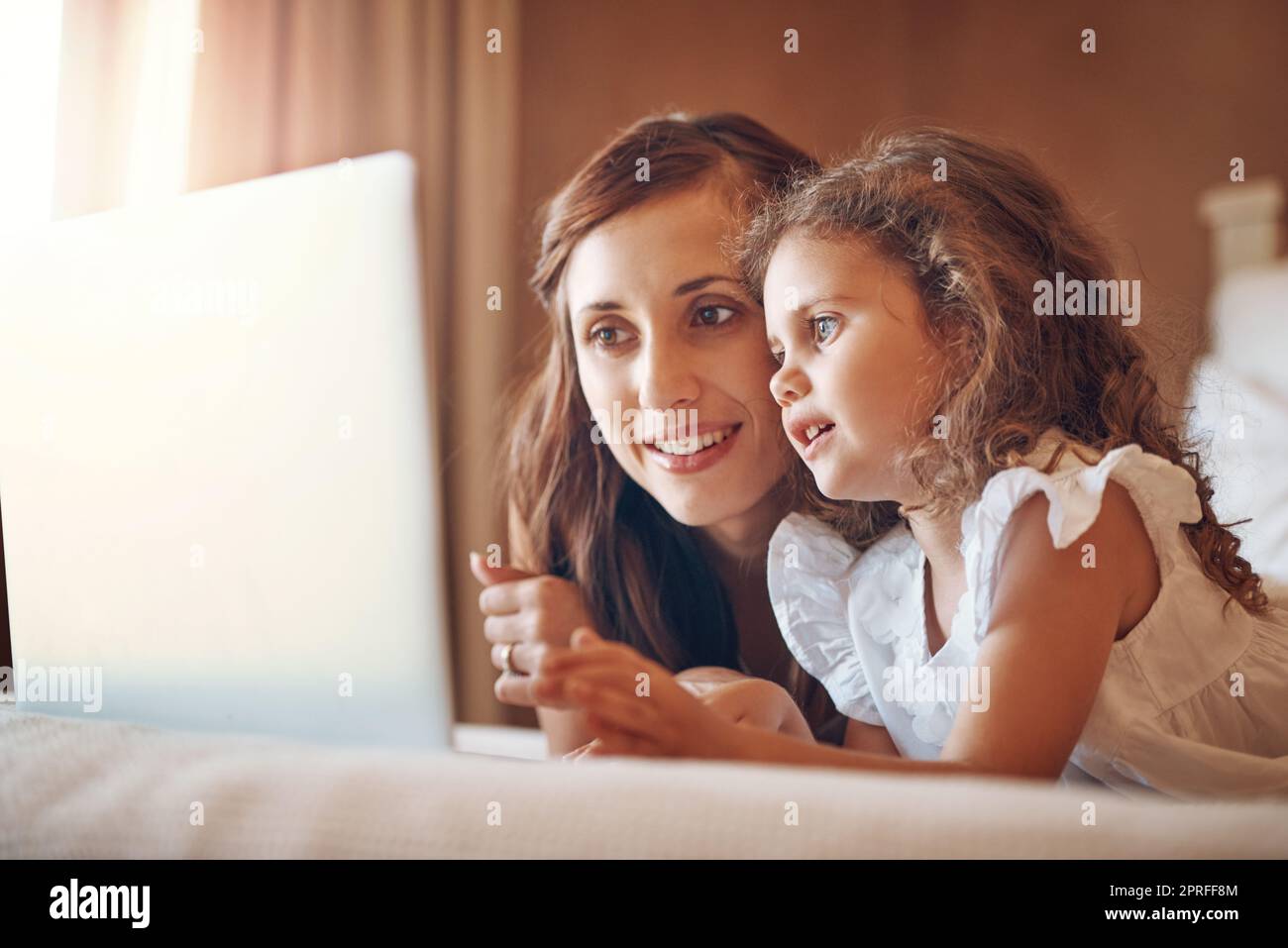 Imparare e unire attraverso il mondo online. Una madre e sua figlia che usano un notebook insieme a casa. Foto Stock