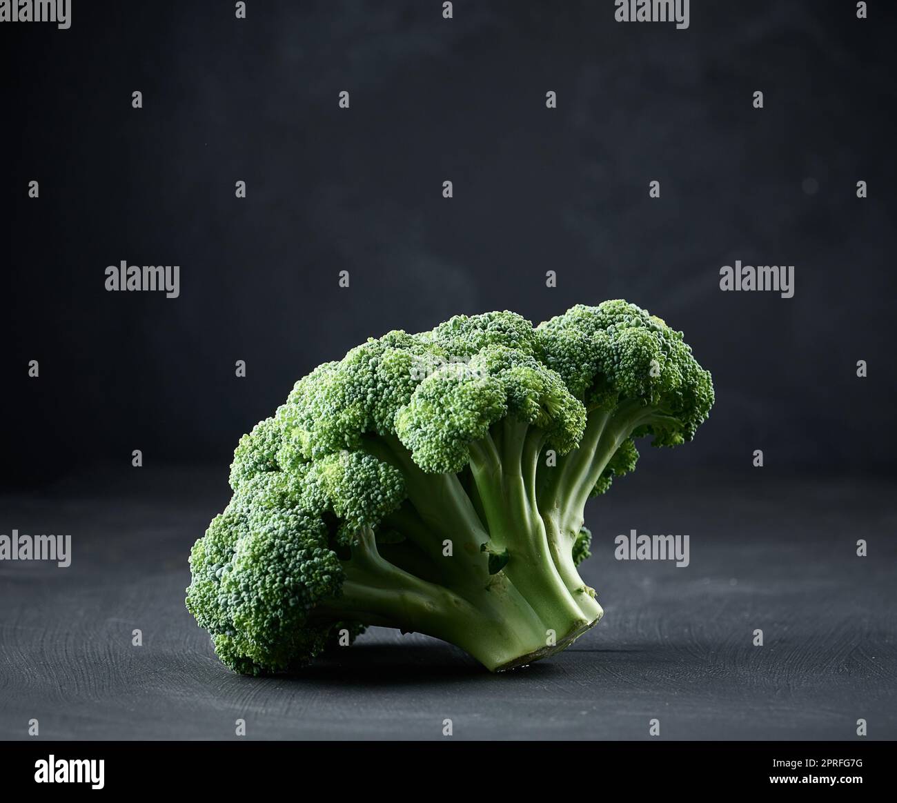 Testa verde di broccoli freschi su sfondo nero. Foto Stock