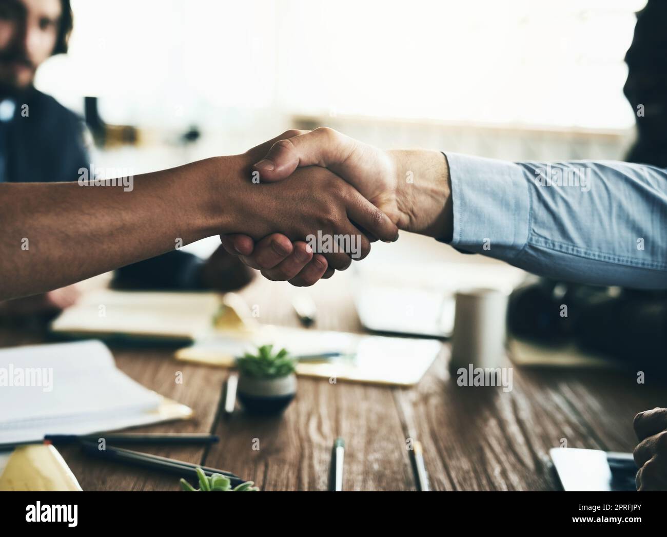 Facciamo grandi cose insieme. Due uomini d'affari non identificabili scuotono le mani sul tavolo della sala riunioni durante una riunione. Foto Stock