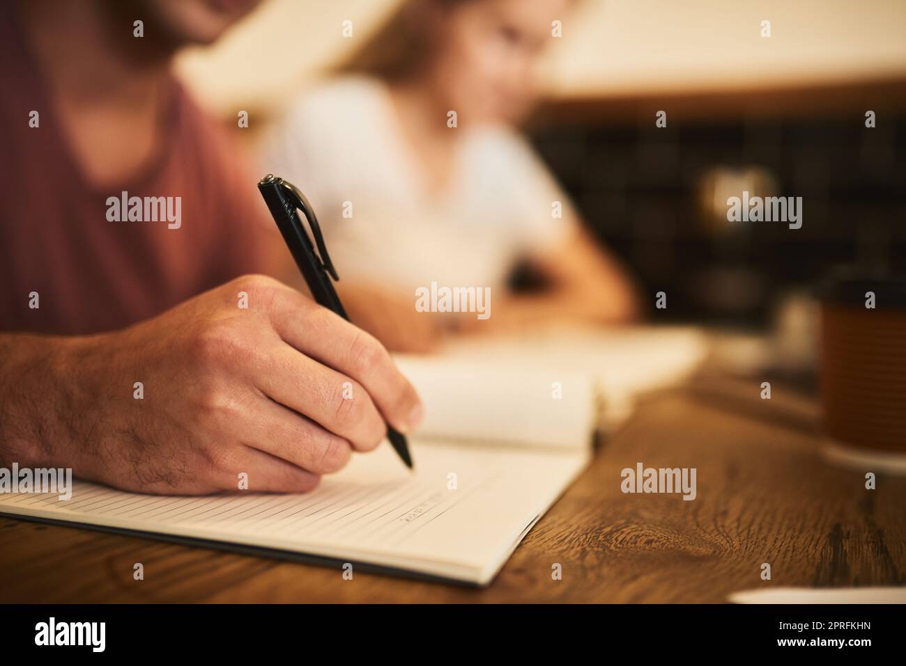 Ridiscendo ogni dettaglio importante. Due studenti non identificabili che hanno una sessione di studio ad un tavolo da caffè. Foto Stock