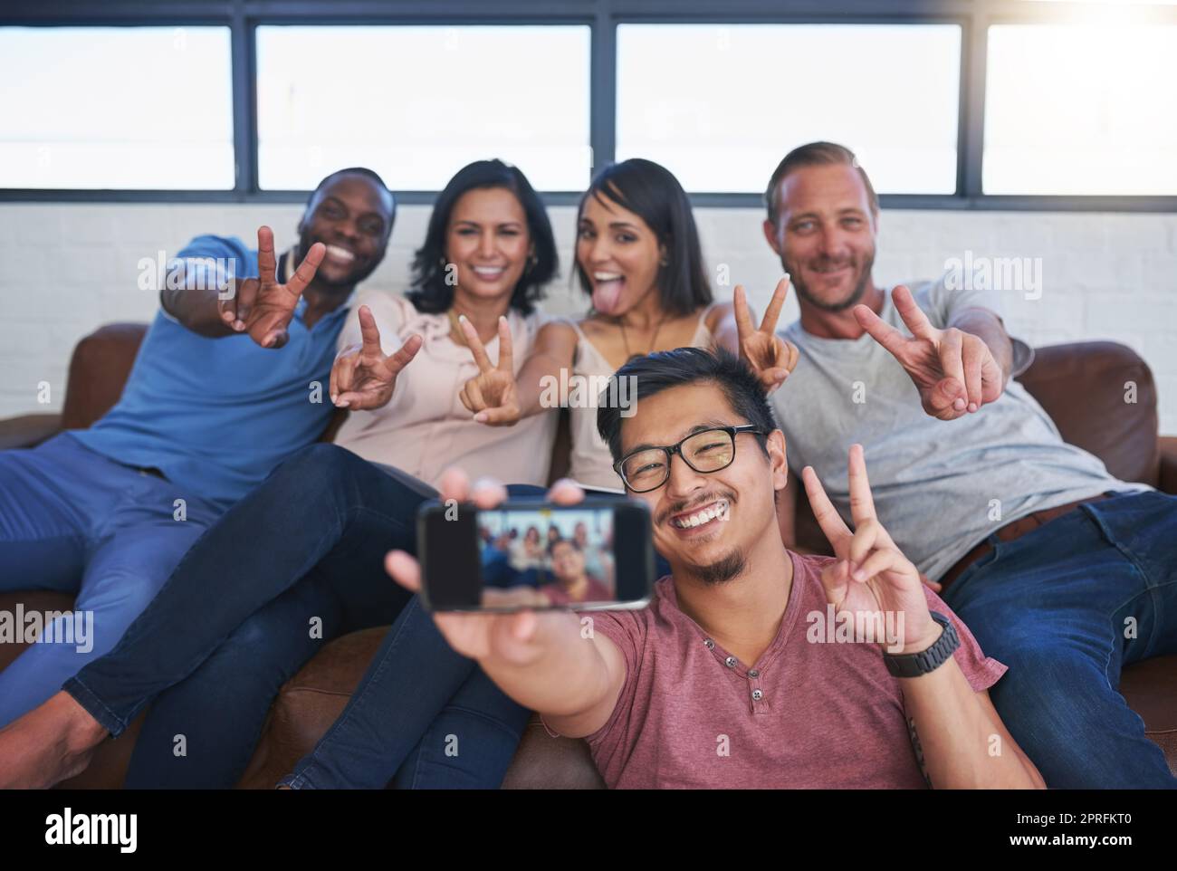 Theyre nel commercio delle buone vibrazioni. Un gruppo felice dei colleghi creativi che si propongono per un selfie insieme nell'ufficio. Foto Stock