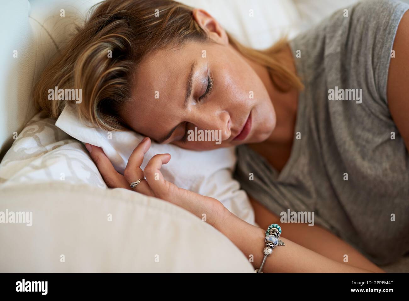 Dormi tranquillamente, svegliati felicemente. Primo piano scatto di una donna attraente che dorme sul suo fianco a letto a casa. Foto Stock