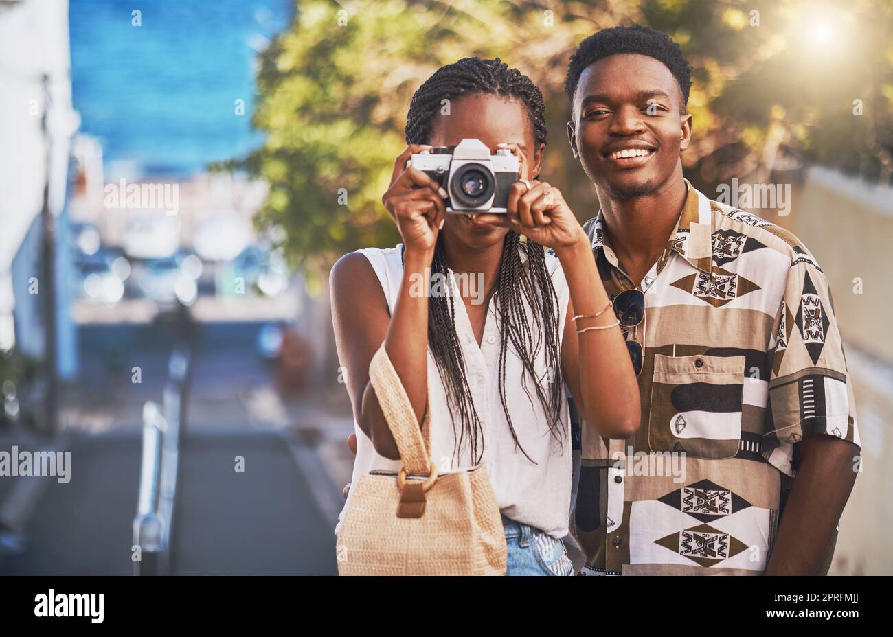 Viaggi, turismo e giovani coppie nere che scattano foto con una macchina fotografica, si divertono e camminano in città. Fidanzato afro-americano e fidanzata che si godono la loro relazione e il loro viaggio insieme Foto Stock