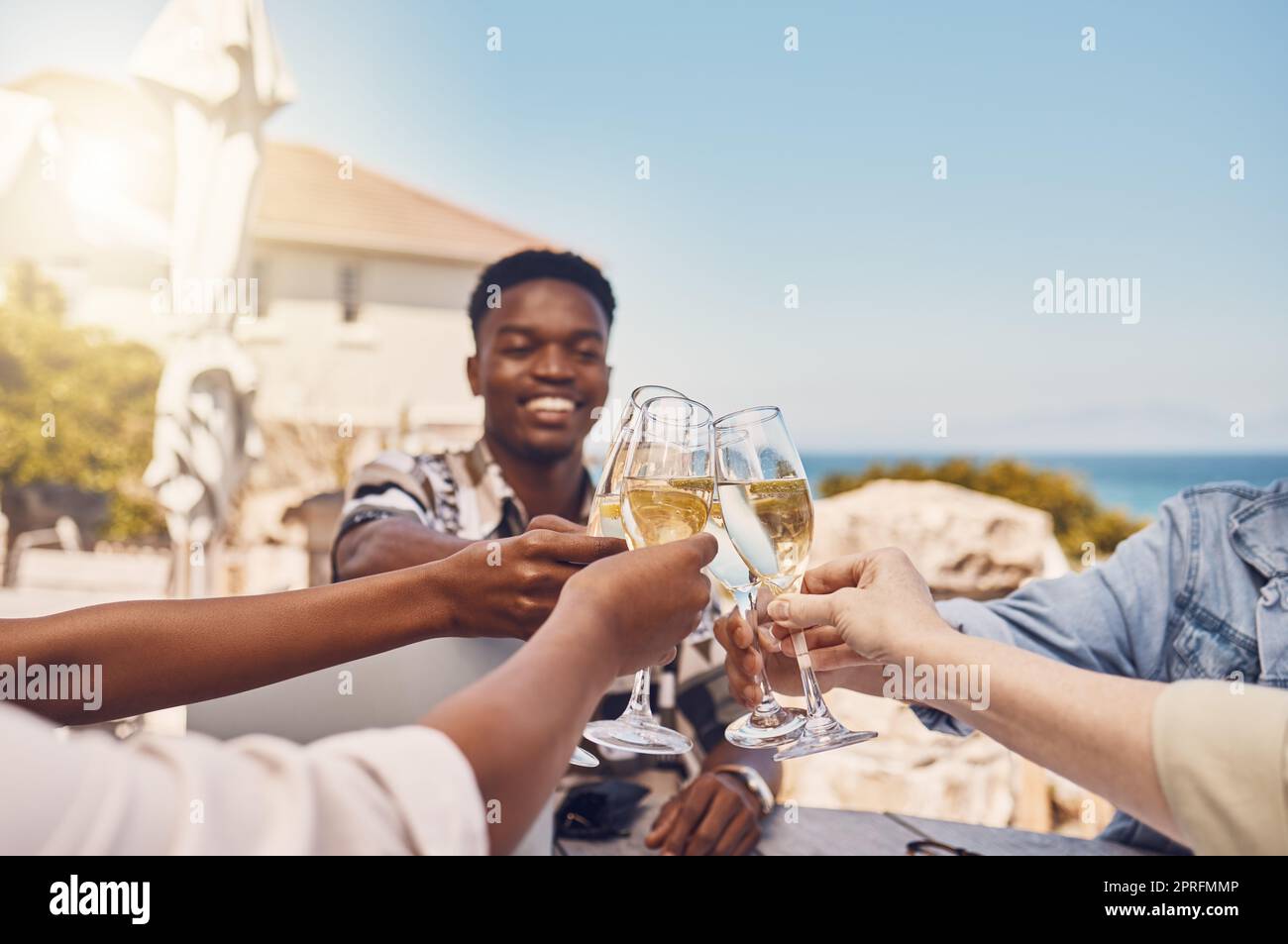 Festeggiamenti, alcolici e brindisi con gli amici con vino in un ristorante all'aperto, felice e divertente. Giovani diversi che si riuniscono per celebrare la libertà, il compleanno, l'amicizia o buone notizie con gli applausi Foto Stock