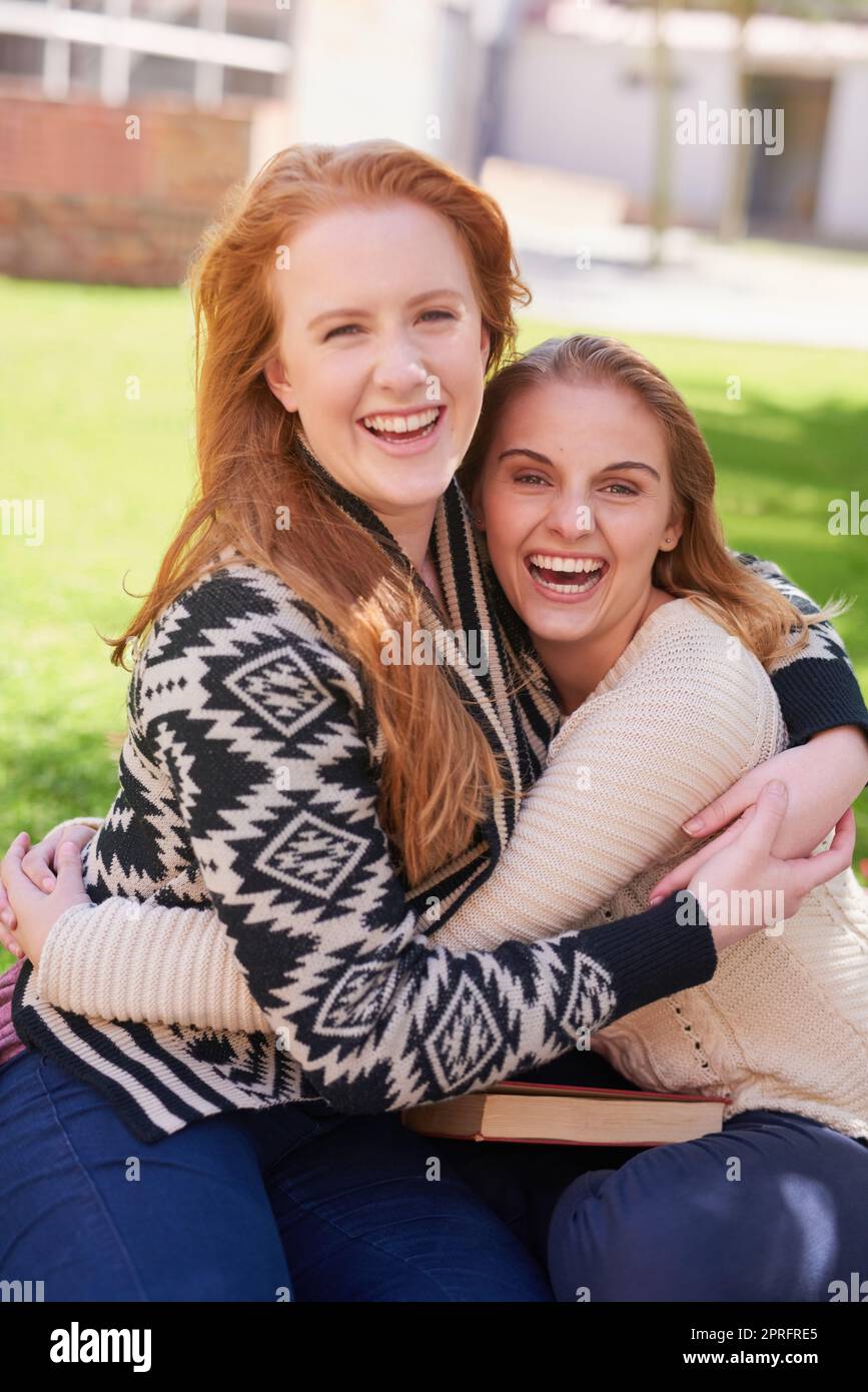 Forgiare amicizie di lunga durata al college. Due amici felici che abbraccia all'aperto. Foto Stock