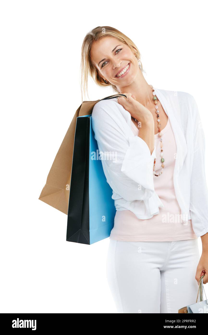 Premiarmi con un po' di terapia al dettaglio. Studio ritratto di una giovane donna felice che porta borse da shopping su uno sfondo bianco. Foto Stock