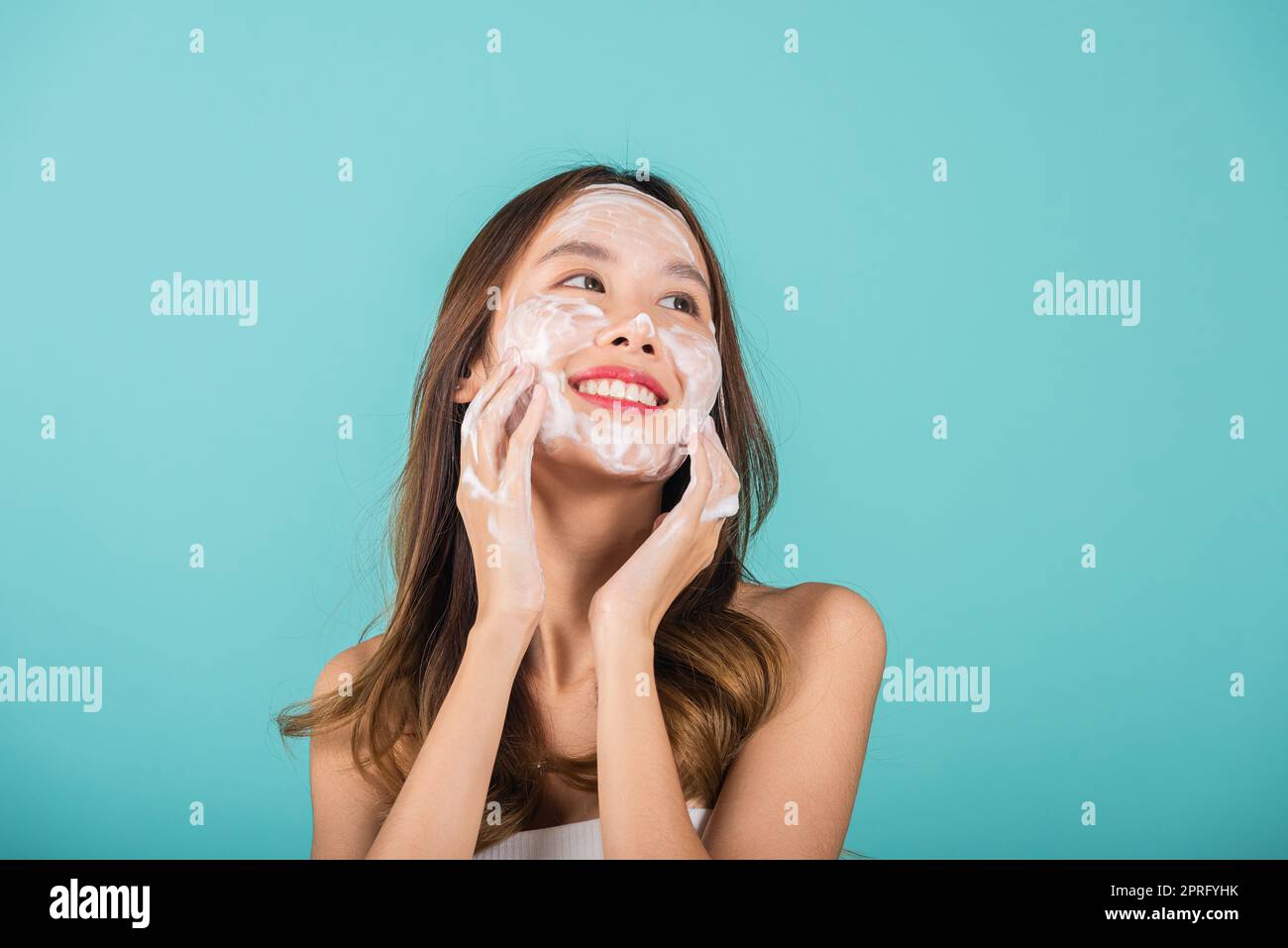 Donna asiatica viso lavaggio esfoliate scrub schiuma sapone con pulizia della pelle, ritratto bella donna sorriso applica schiuma detergente pelle sana, Studio Foto Stock