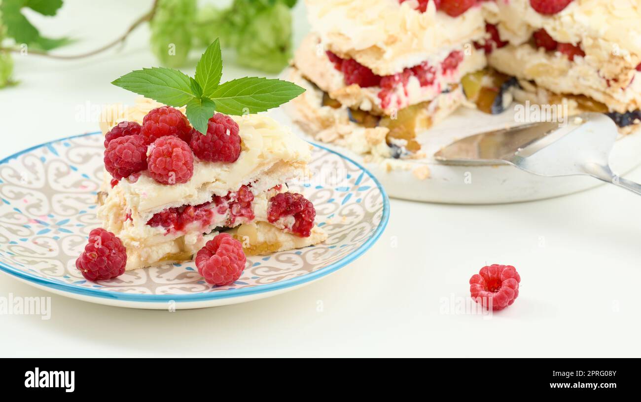 Torta di meringa rotonda con lamponi freschi su sfondo bianco, Pavlova dessert Foto Stock