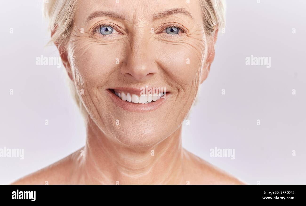 Ritratto di una donna anziana felice che affronta sullo sfondo di un modello da studio. Modello maturo sano e naturale con pelle liscia. Sentirsi radioso e fresco con la sua routine cosmetica di cura della pelle o della salute Foto Stock