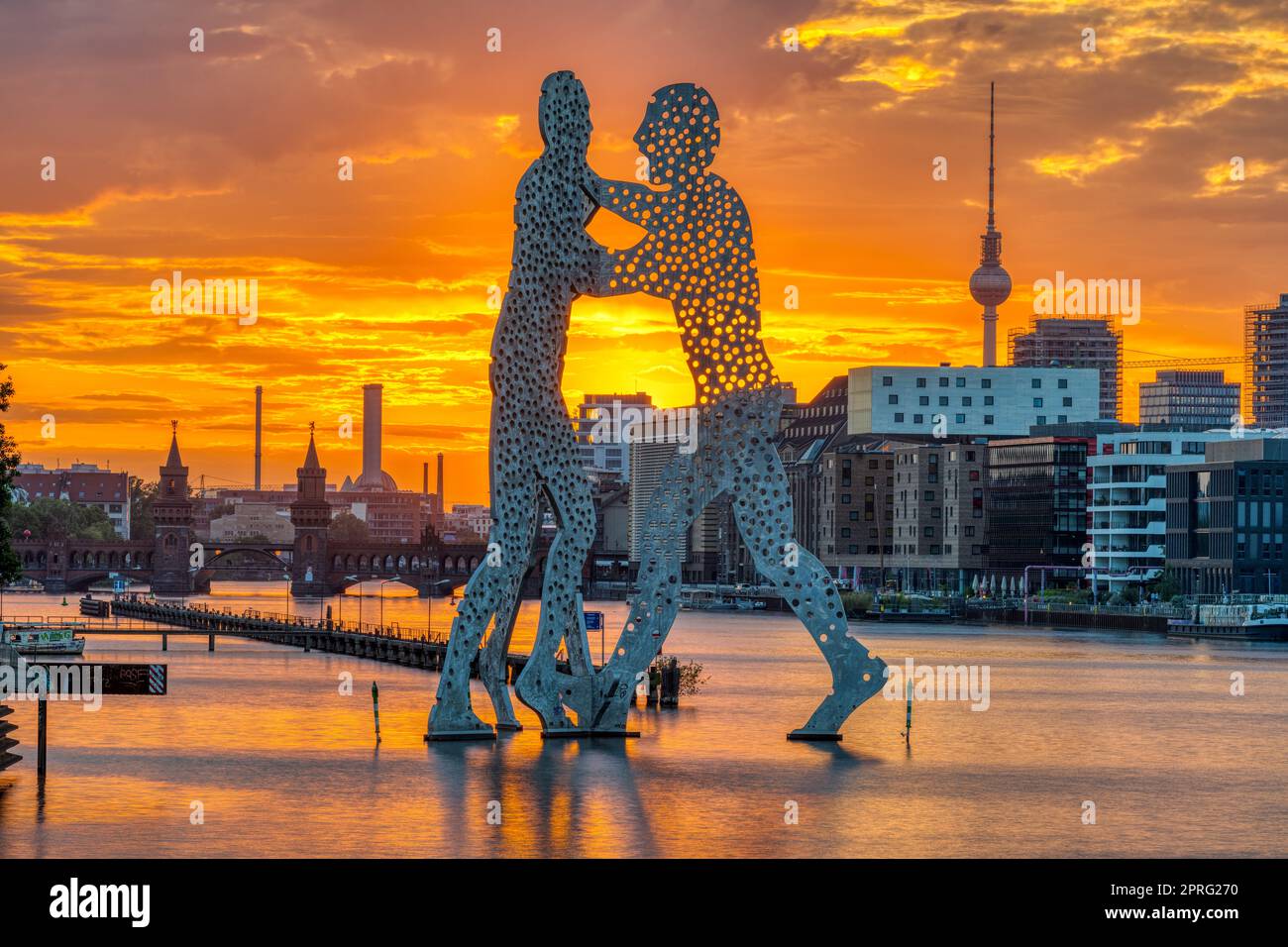 Tramonto a Berlino con il fiume Sprea, la scultura Molecule Men e la torre della televisione Foto Stock