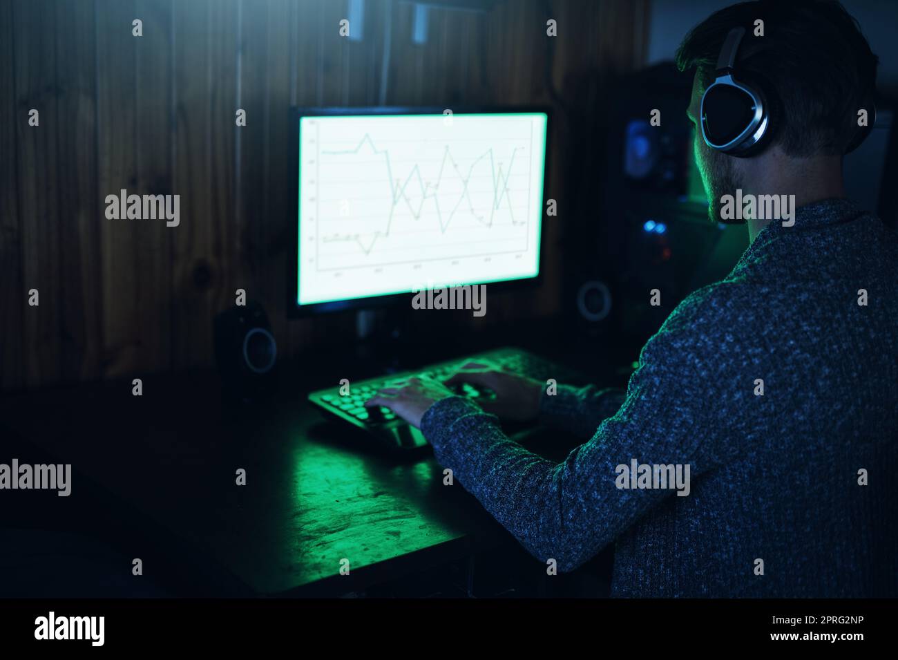 Ha appena violato un firewall. Un giovane uomo che usa un computer e che hacking in una stanza buia a casa. Foto Stock