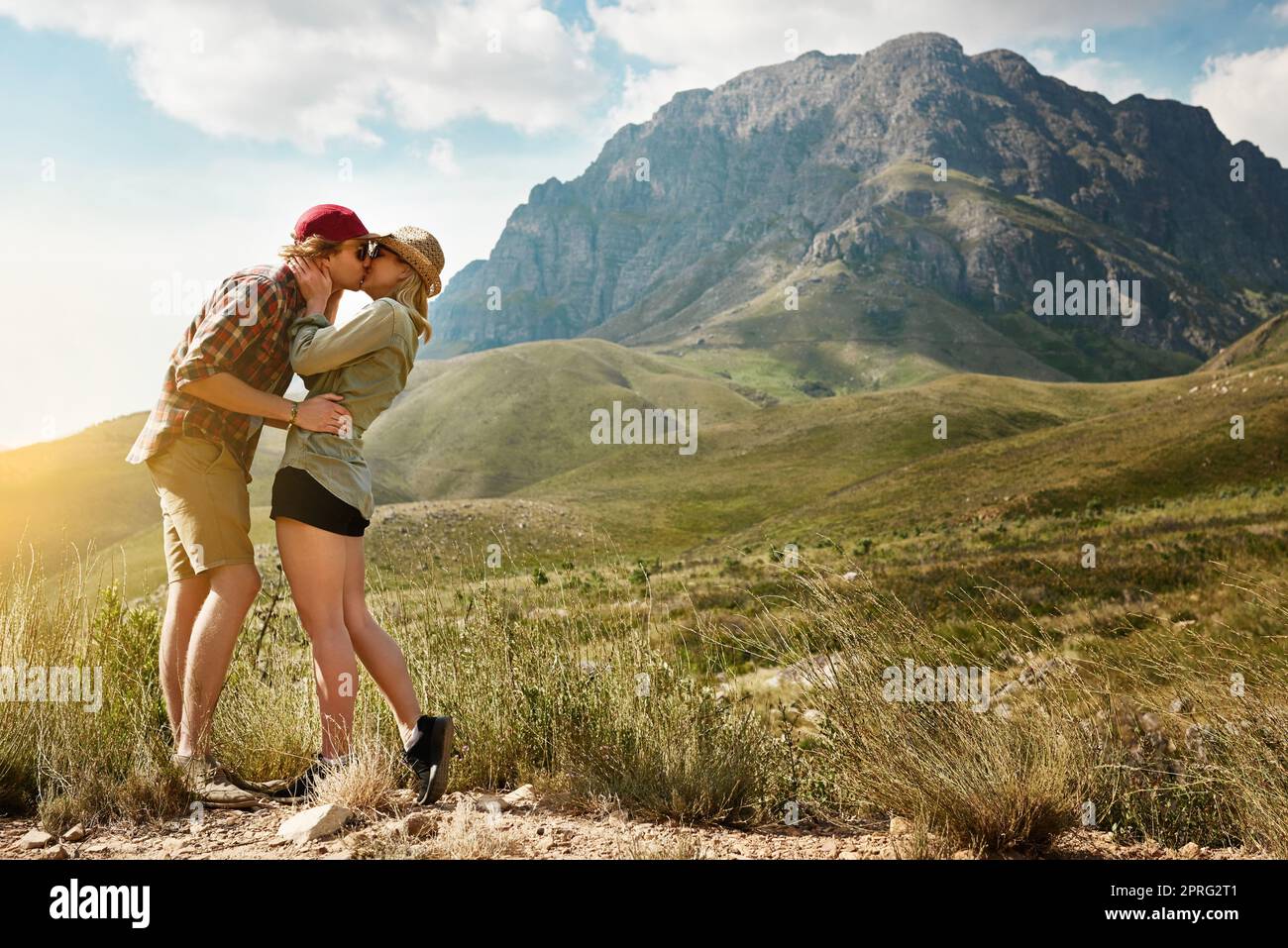 Amore per sentirsi vivi. Una giovane coppia affettuosa che condivide un bacio nella natura. Foto Stock