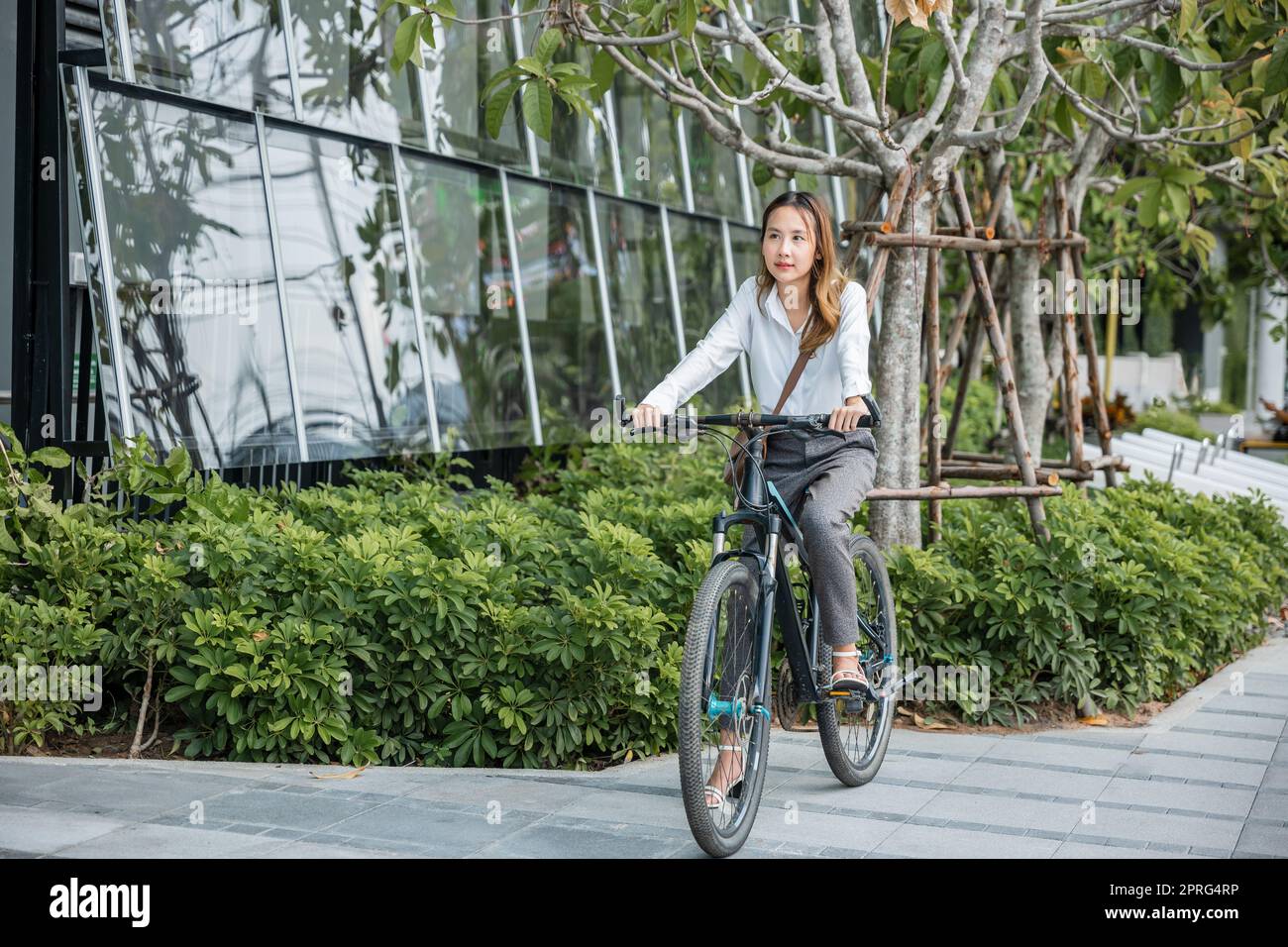 giovane donna d'affari con casco in bicicletta andare in ufficio lavoro Foto Stock