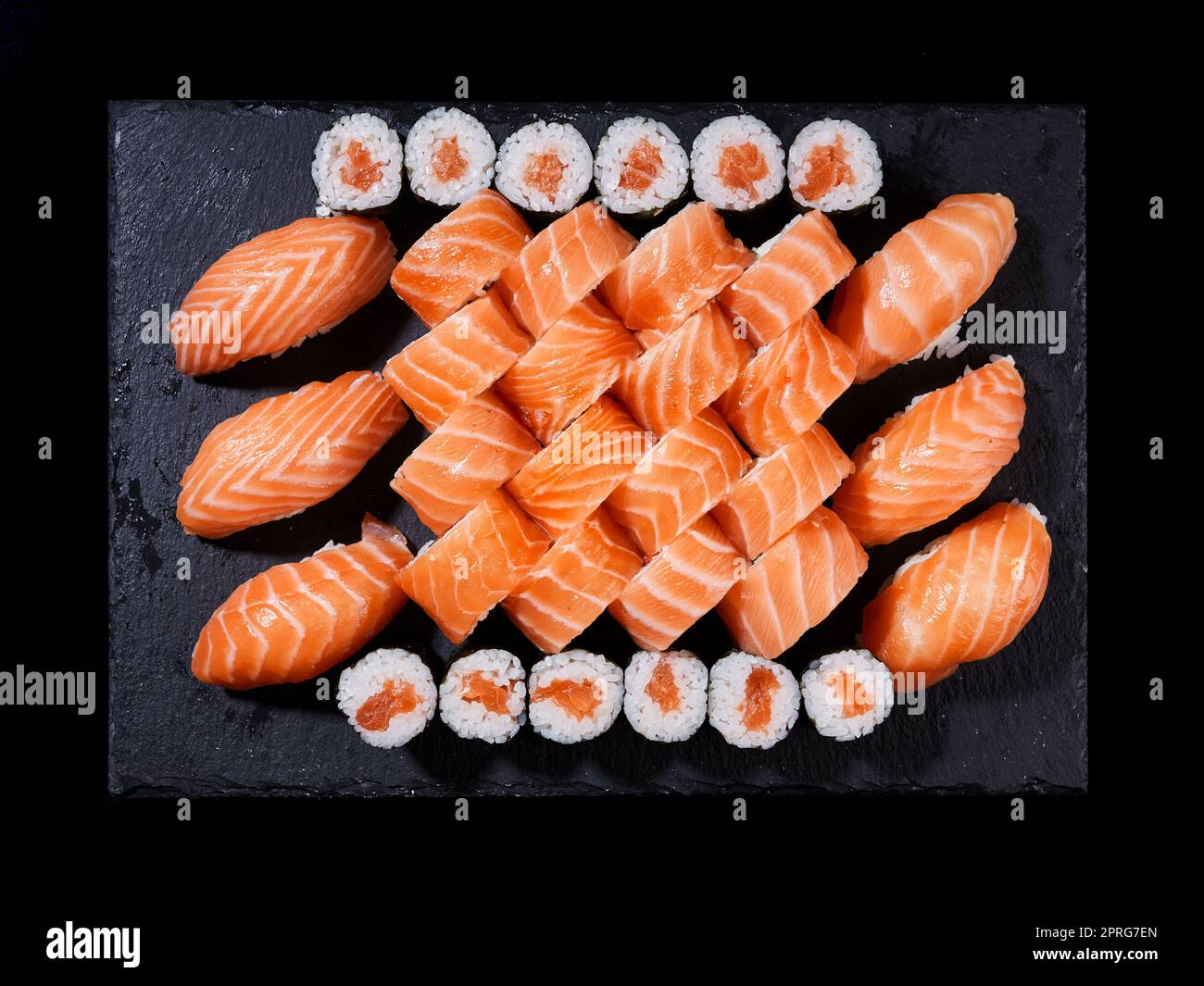 Vista dall'alto sushi Rolls philadelphia, sashimi e maki su un piatto di ardesia nera. Foto Stock