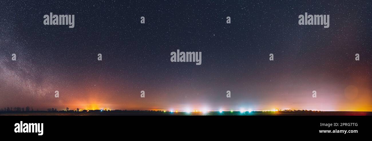 Cielo stellato di notte con le stelle incandescenti sopra il paesaggio di campagna. Milky Way Galaxy e campo rurale prato in primavera. Panorama, Vista panoramica Foto Stock