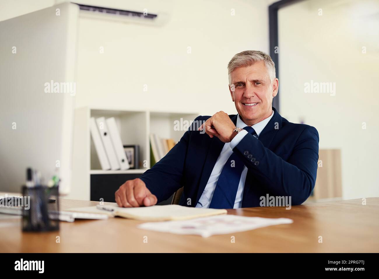 Il suo lavoro ha preso duro per atterrarmi questa posizione superiore. Ritratto di un uomo d'affari fidato e maturo seduto alla sua scrivania in un ufficio. Foto Stock