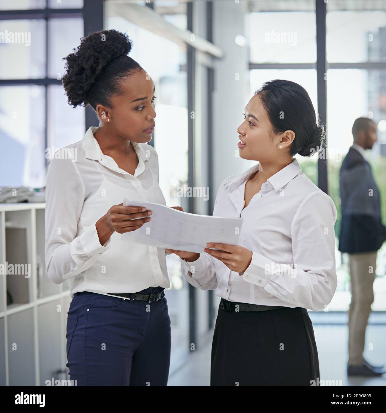 Dimmi di più, mentre ascolti, due colleghi di lavoro che discutono di affari in ufficio. Foto Stock