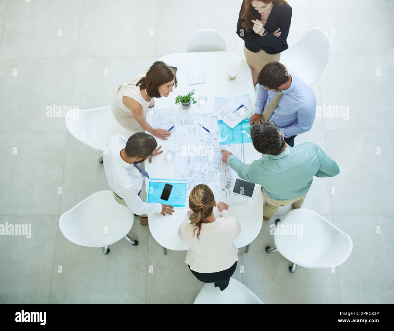 Prendersi cura del business. Immagine ad angolo alto di un gruppo di uomini d'affari che si riunano in ufficio. Foto Stock