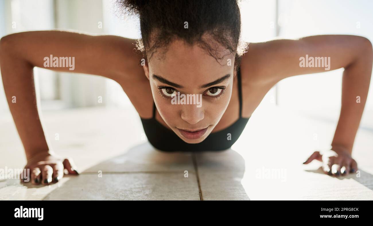 Lavorando per il corpo che vuole. Ritratto di una giovane donna sportiva che fa push-up all'esterno. Foto Stock
