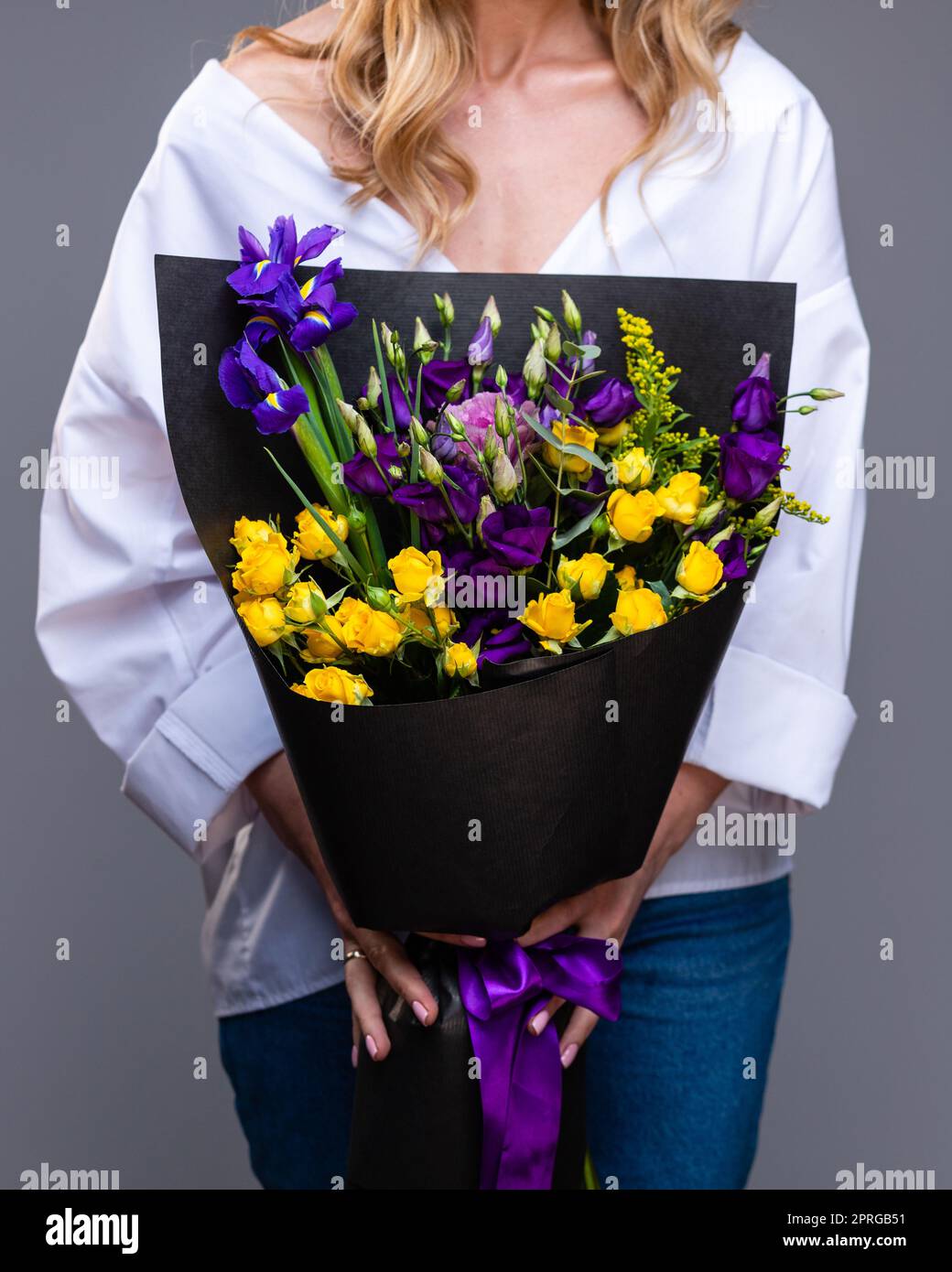 Elegante bouquet di rose e di eustoma nelle mani di una donna bionda. Foto Stock