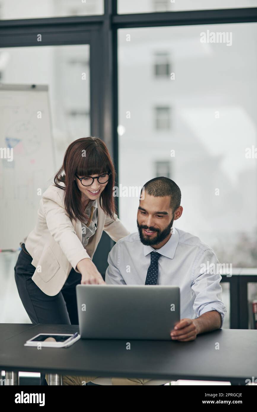 Dandogli qualche riferimento, due giovani uomini d'affari che lavorano in ufficio. Foto Stock