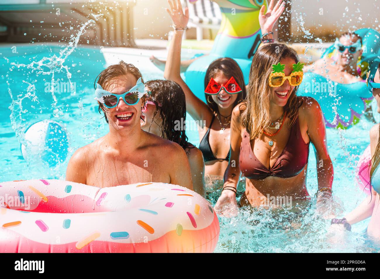 Gruppo di amici in costume da bagno godere in una piscina Foto Stock