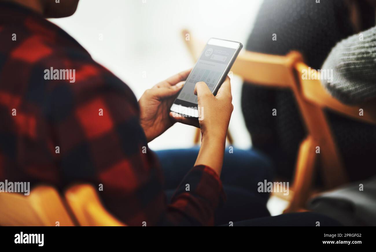 Devo parlarne ai miei amici: Una persona irriconoscibile che usa il telefono mentre è seduto in una sala conferenze. Foto Stock