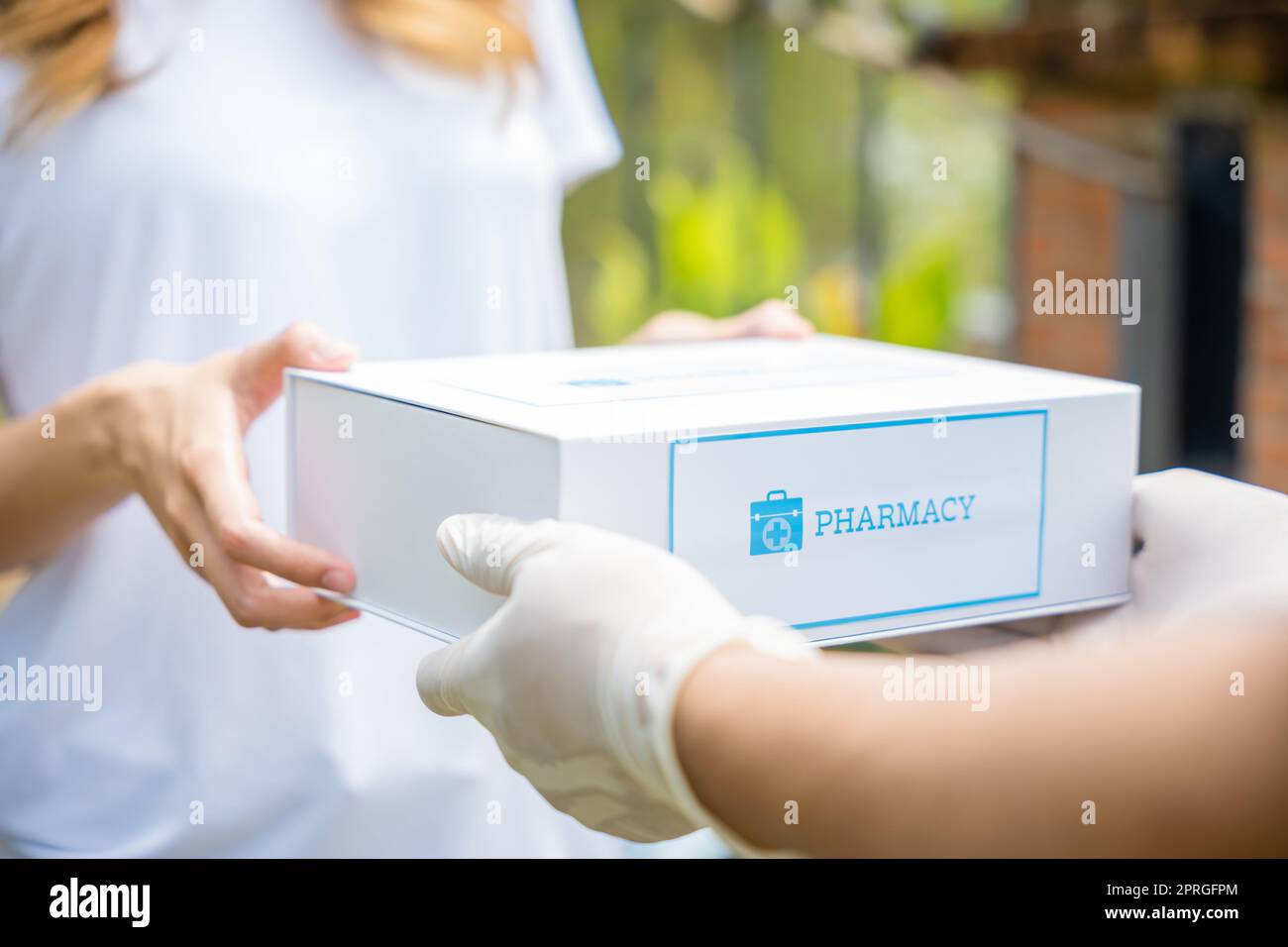 La giovane donna asiatica malata riceve la scatola della farmacia di pronto soccorso della medicina dal servizio di consegna dell'ospedale Foto Stock