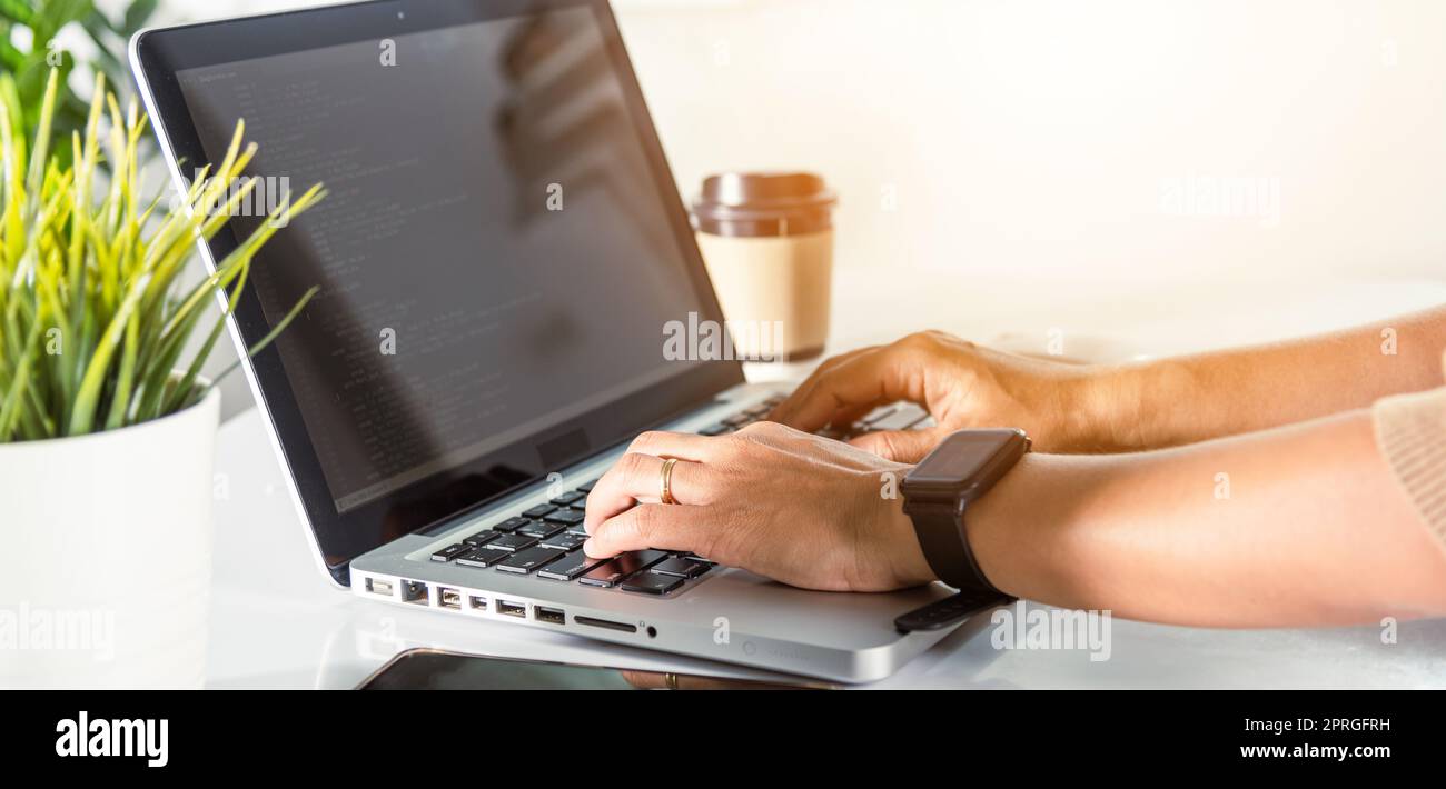 programmatore donna che scrive il codice di programma seduto sul posto di lavoro in ufficio Foto Stock