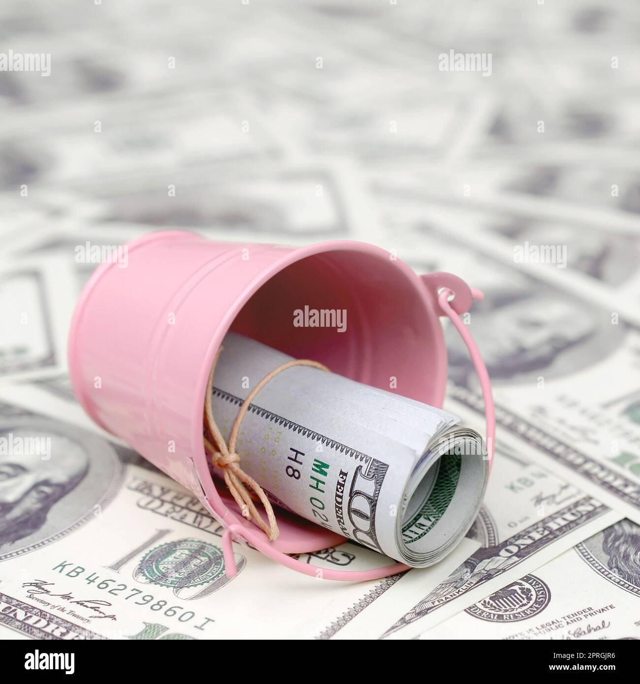 Un fascio di dollari USA in un metallo rosa secchio su una serie di fatture del dollaro. Il concetto di abbondanza e di contante in eccesso Foto Stock