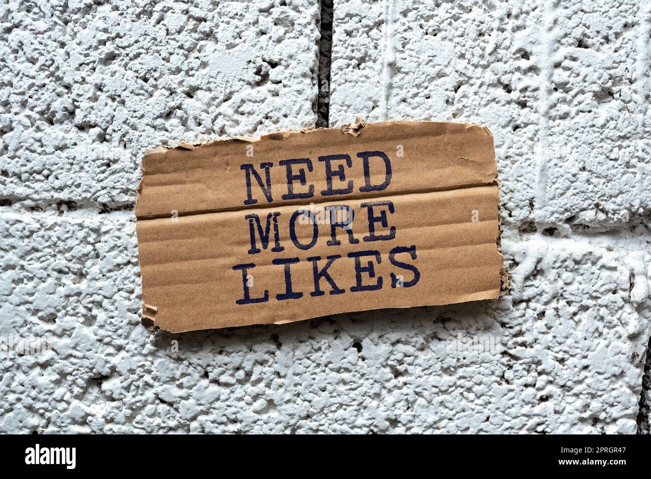 I testi scritti a mano hanno bisogno di più mi piace. Concetto che significa la necessità di avere altri follower imprenditori di social network che puntano informazioni importanti con Pen in mano. Foto Stock